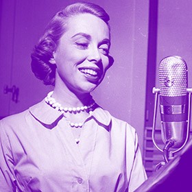 purple-tinted photo of a woman speaking into a microphone, circa 1950s